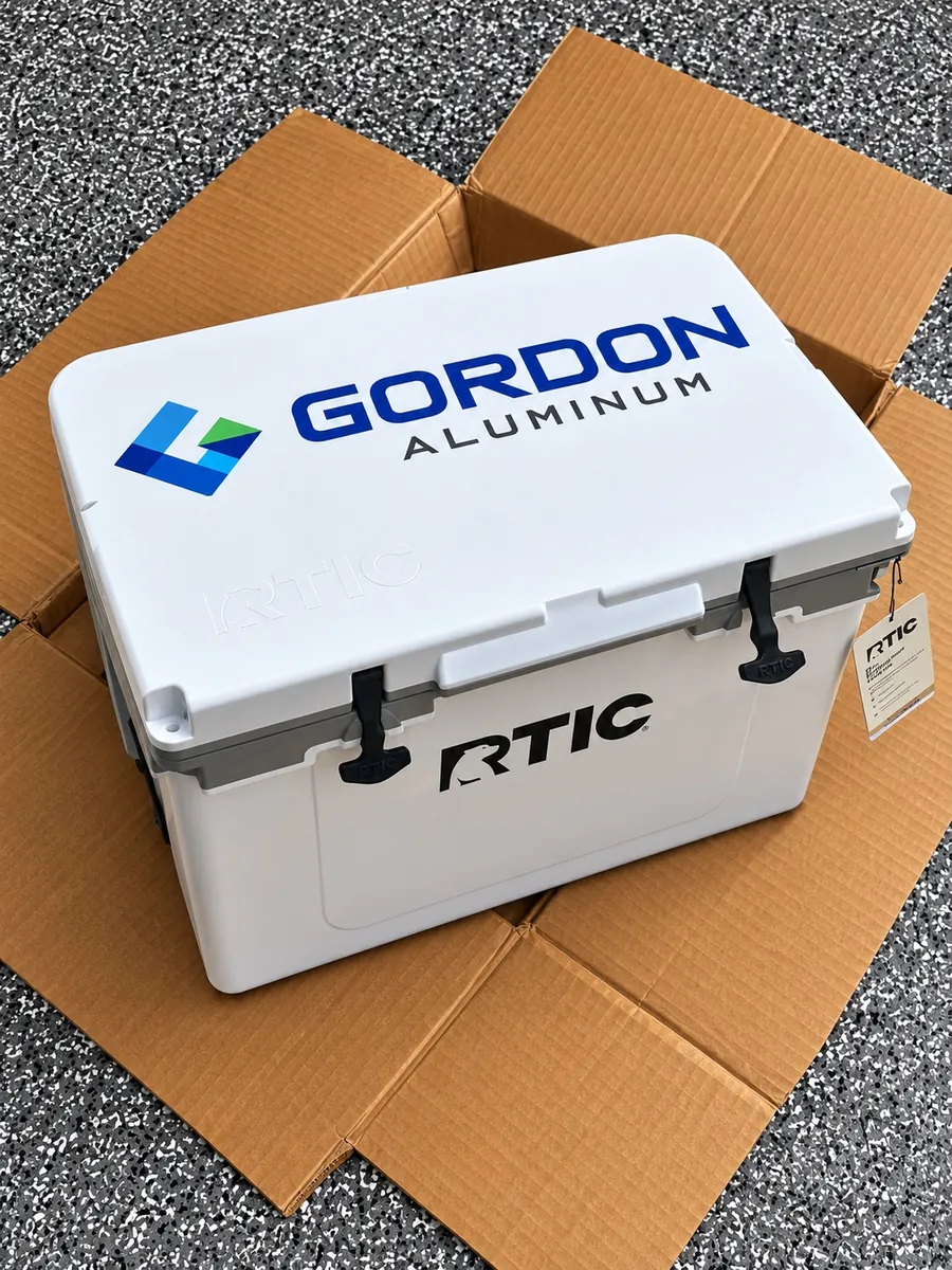 Angled view of a white RTIC cooler with a Gordon Aluminum logo on the lid, a custom corporate gift made in Wausau, WI