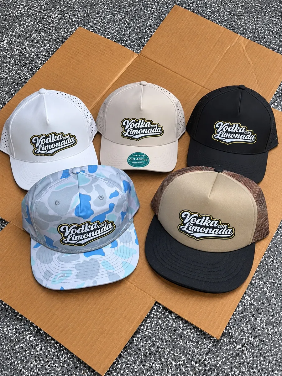Five custom caps in white, tan, black, blue camo and foam trucker styles with the Vodka con Limonada logo, made in Wausau, WI